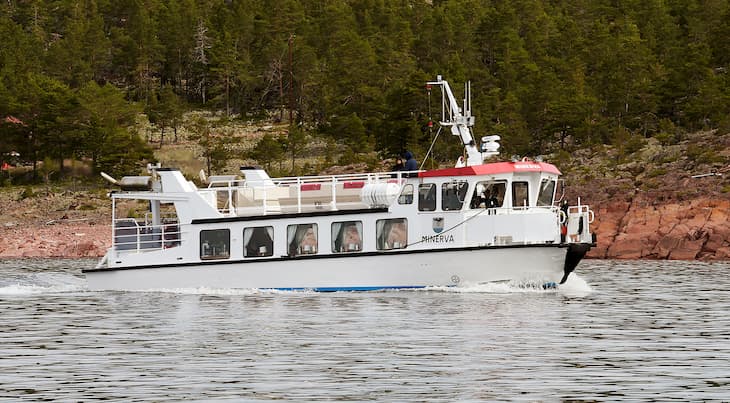 Båten M/F Minerva kör vid strandkanten på väg till Ulvön. 