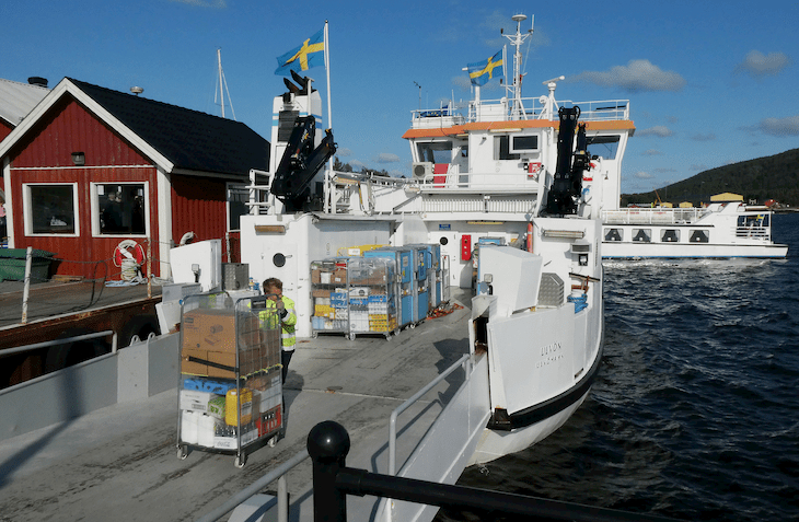 Lastning pågår av gods vid kajen i Köpmanholmen. En rullhäck körs ombord på m/f Ulvön.